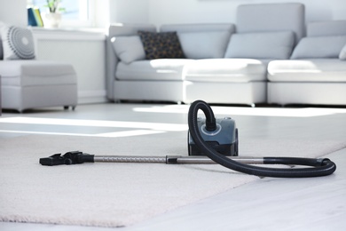 Photo of Vacuum cleaner on floor indoors. Cleaning service