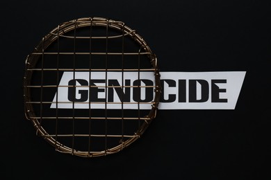 Photo of Word Genocide and golden decor with lattice on black background, flat lay