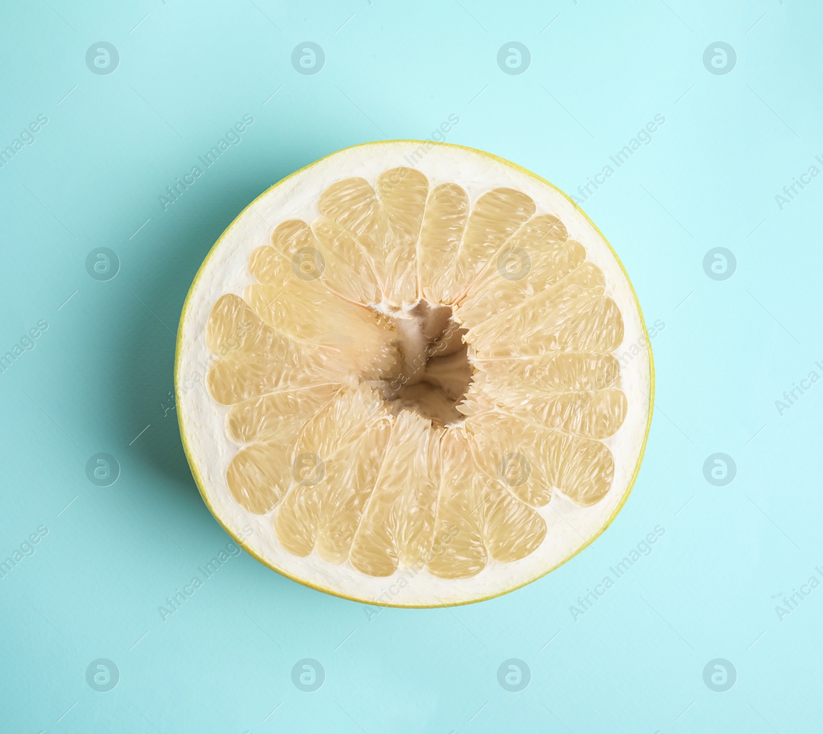 Photo of Fresh cut pomelo fruit on light blue background, top view