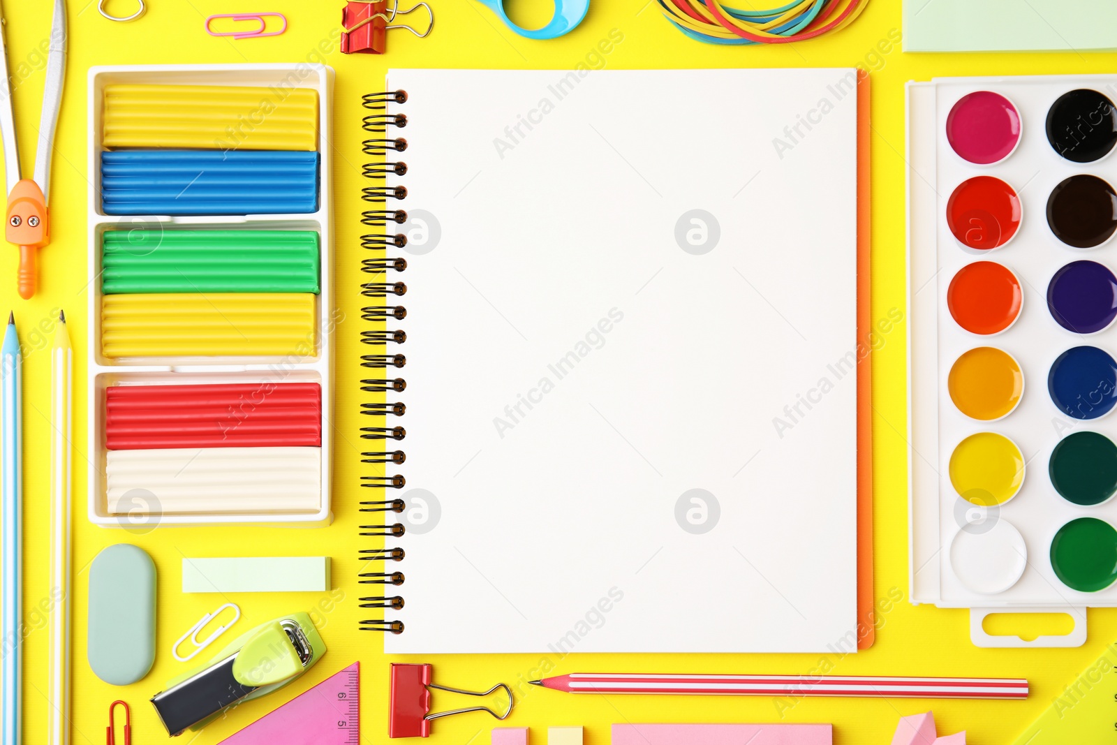 Photo of Flat lay composition with different school stationery on yellow background, space for text. Back to school