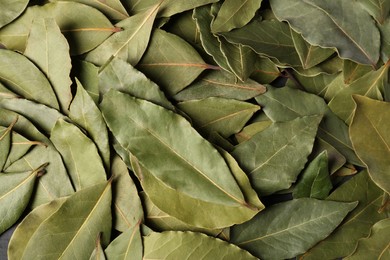 Photo of Pile of aromatic bay leaves as background, top view