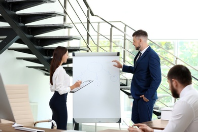 Photo of Man helping his colleague to give presentation on meeting in office