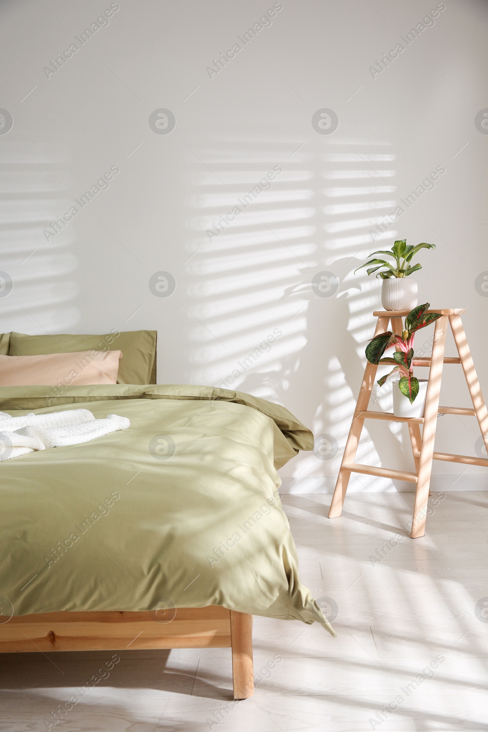 Photo of Large bed with soft blanket in stylish room interior