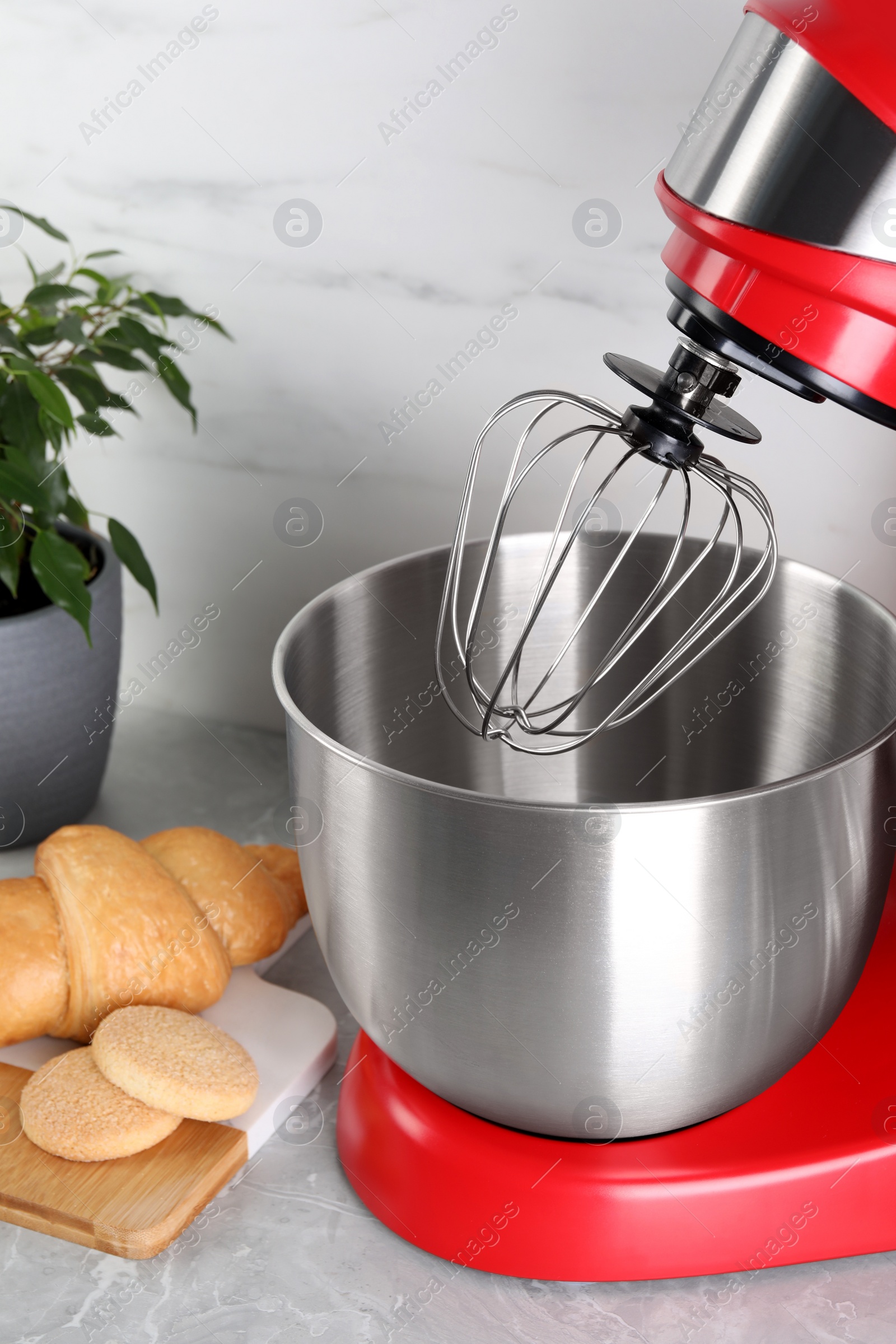 Photo of Modern red stand mixer, croissant and cookies on light gray marble table