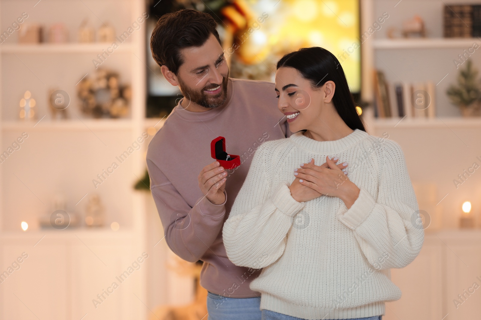 Photo of Making proposal. Man with engagement ring surprising his girlfriend at home on Christmas