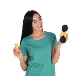 Young woman with menstrual cup and reusable pad on white background