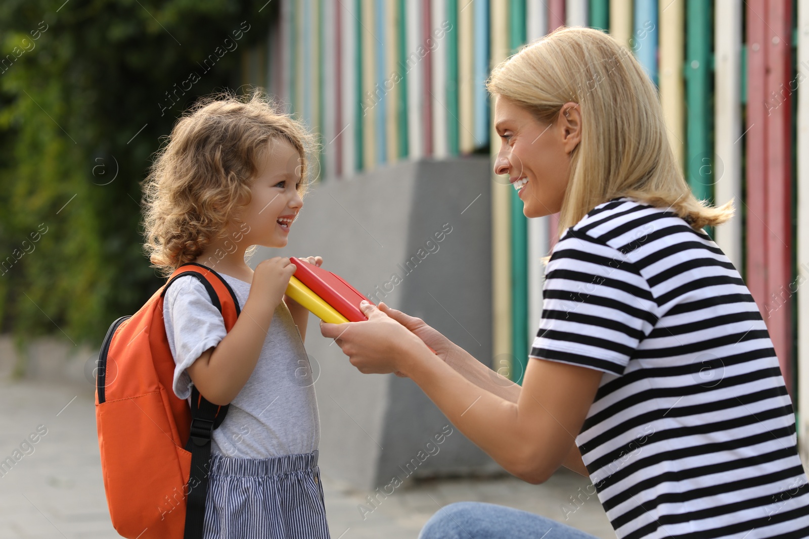 Photo of Happy mother and daughter near kindergarten outdoors