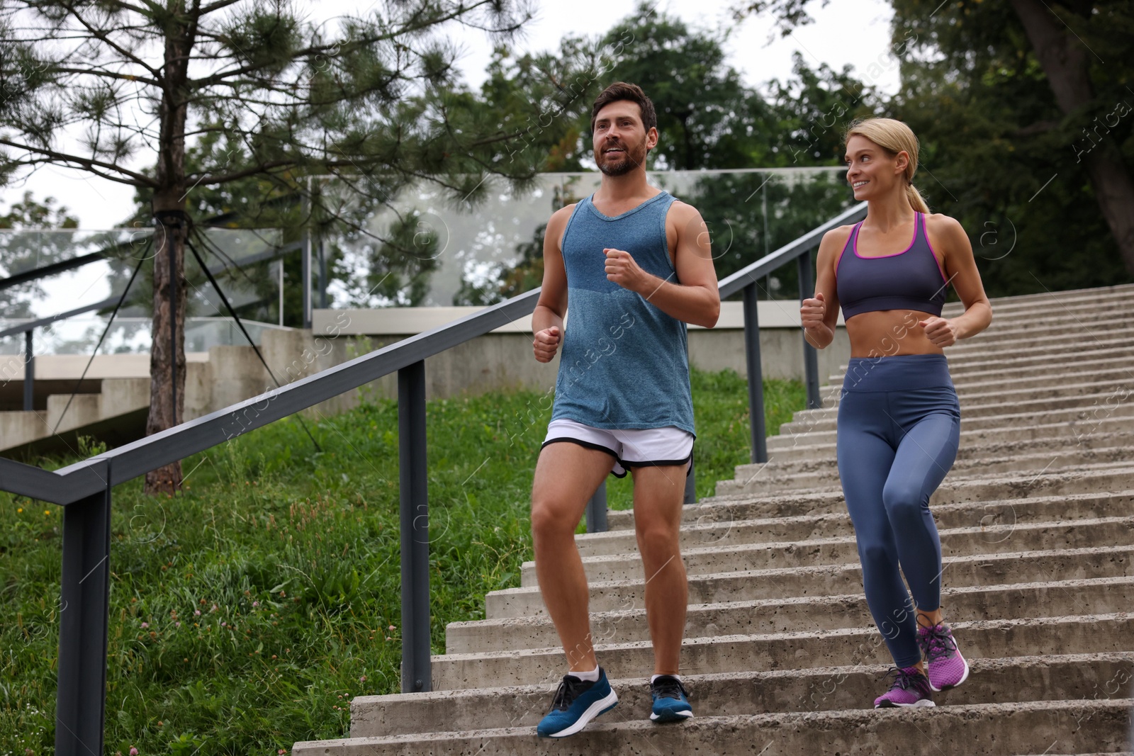 Photo of Healthy lifestyle. Happy couple running down stairs outdoors