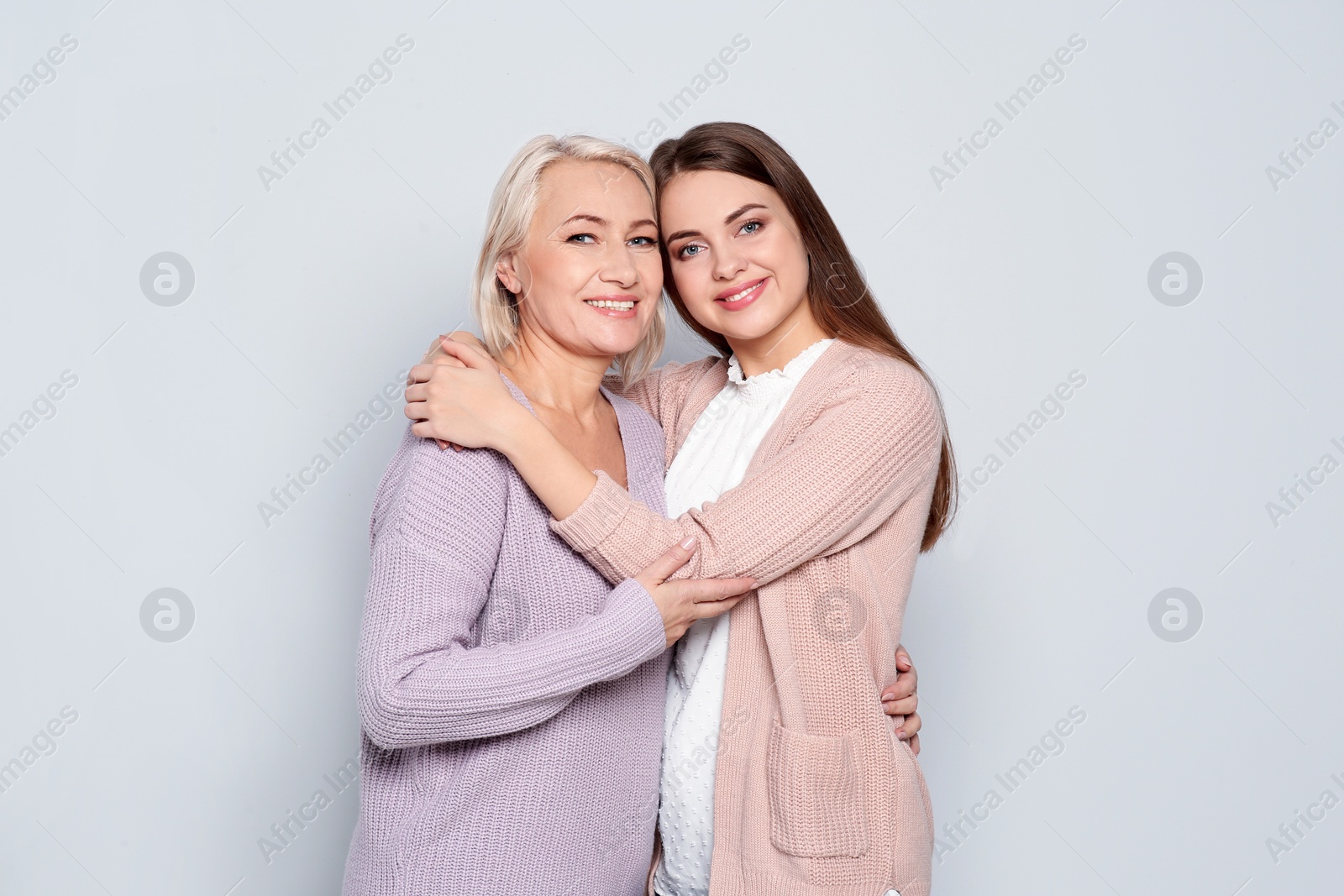 Photo of Portrait of mature woman and her daughter on color background