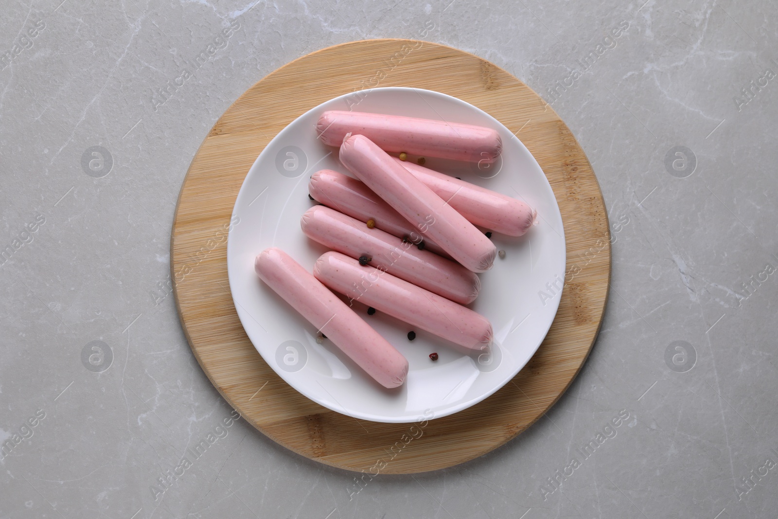 Photo of Vegan sausages with spices on light grey marble table, top view