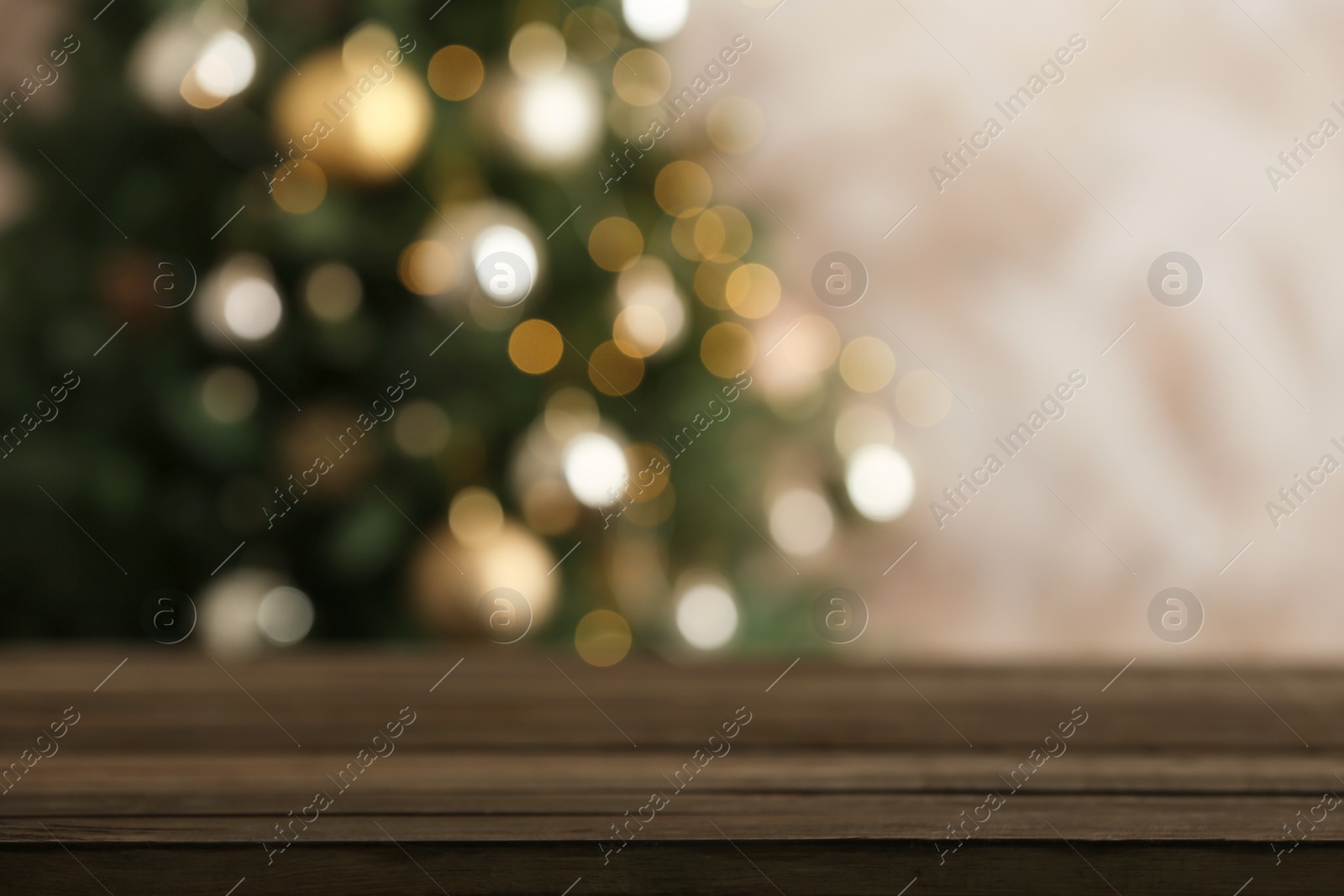 Photo of Empty wooden table and blurred fir tree with Christmas lights on background, bokeh effect. Space for design