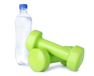 Photo of Stylish dumbbells and bottle of water on white background. Home fitness
