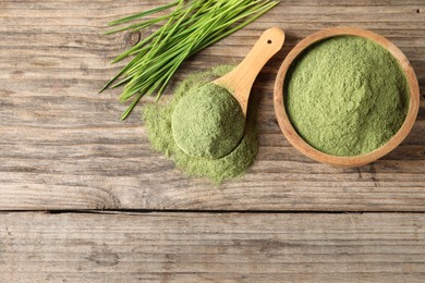 Photo of Wheat grass powder and fresh sprouts on wooden table, flat lay. Space for text