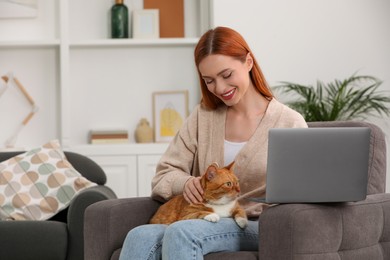 Photo of Happy woman with cat working in armchair at home, space for text