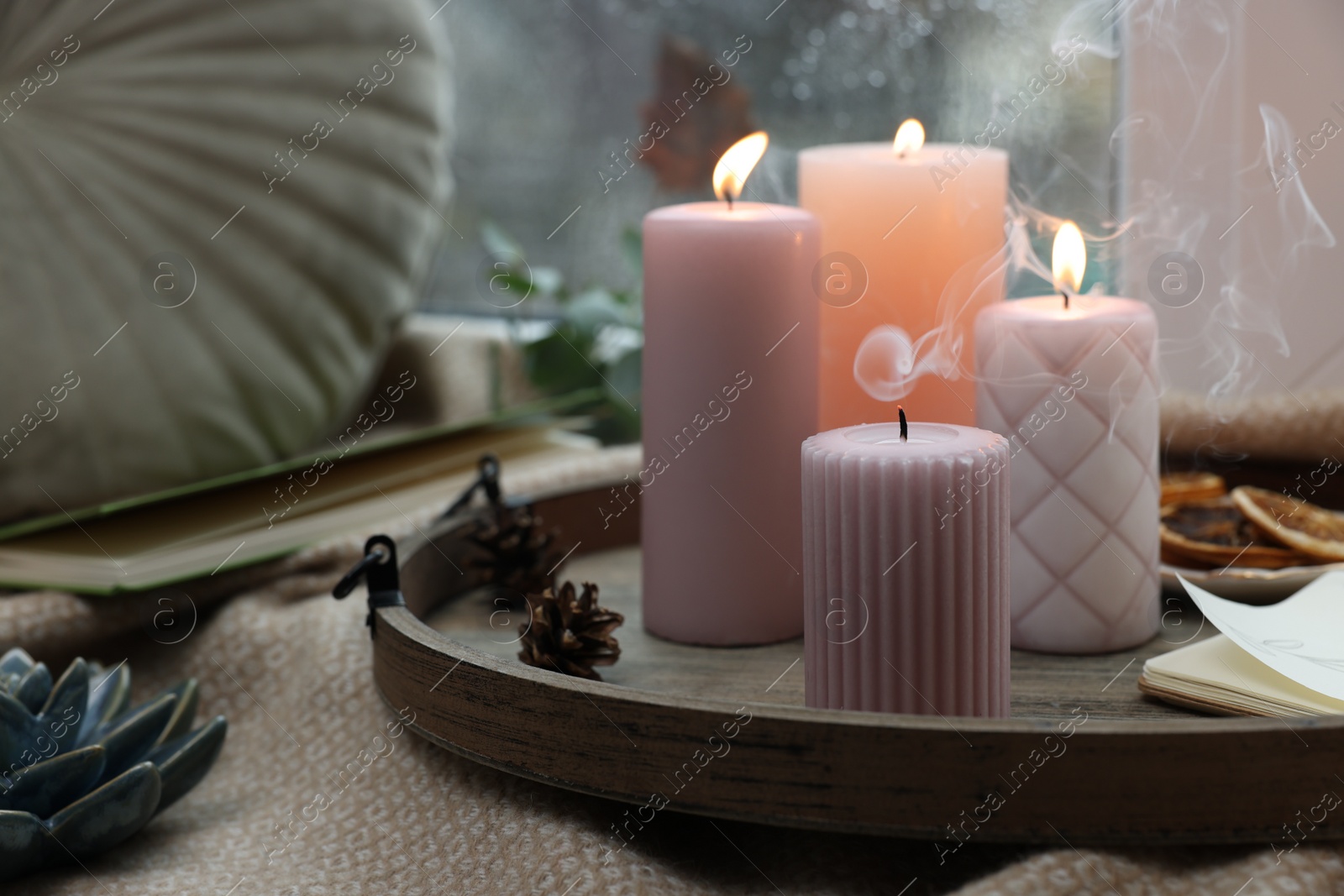 Photo of Tray with wax candles on window sill indoors