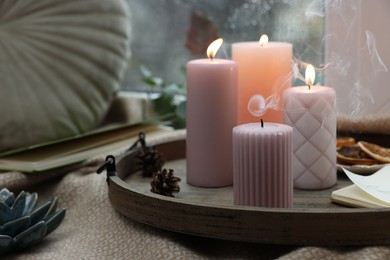 Tray with wax candles on window sill indoors