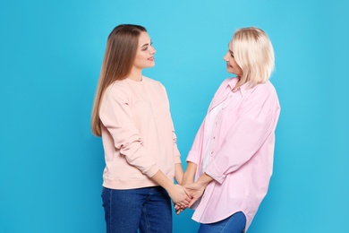 Photo of Portrait of mature woman and her daughter on color background