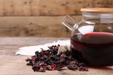 Photo of Freshly brewed hibiscus tea on wooden table, closeup