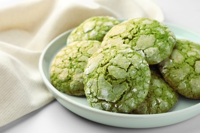 Plate with tasty matcha cookies on white table, closeup
