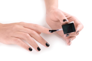 Woman applying nail polish on white background, closeup