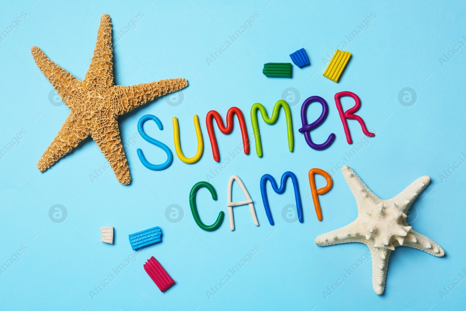 Photo of Flat lay composition with text SUMMER CAMP made of modelling clay on color background