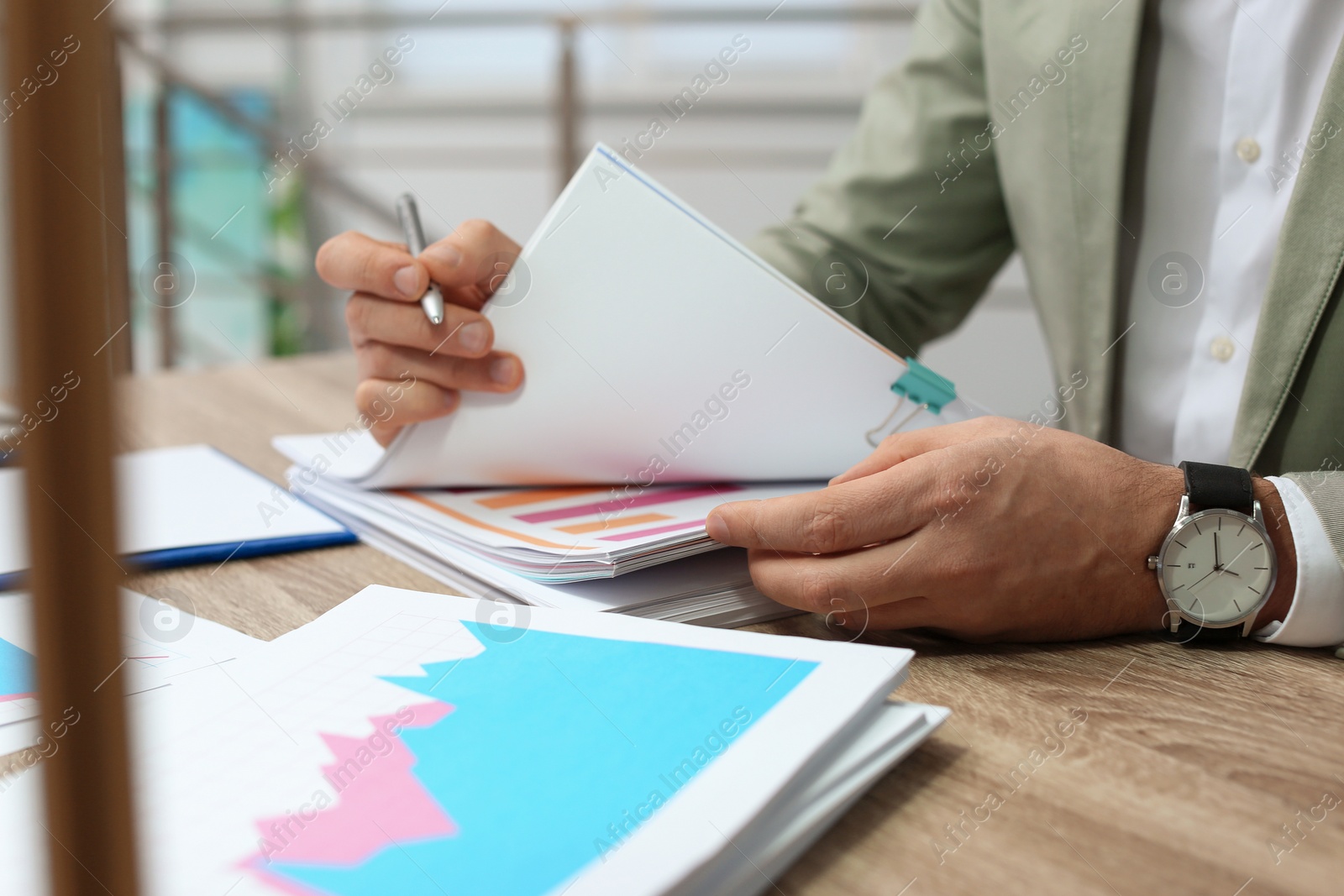 Photo of Businessman working with documents at office table, closeup