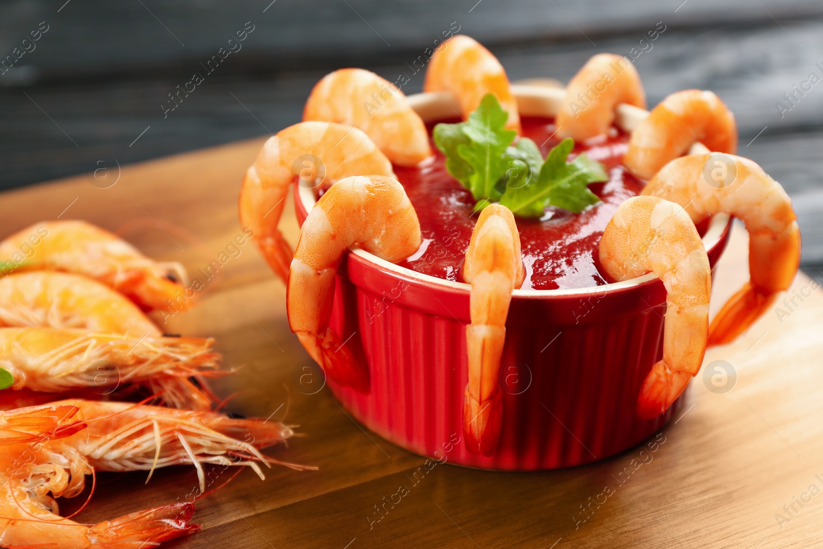 Photo of Delicious shrimp cocktail with tomato sauce served on table, closeup