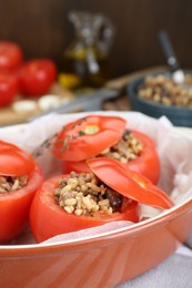 Photo of Uncooked stuffed tomatoes with minced beef, bulgur and mushrooms in baking dish on table, closeup