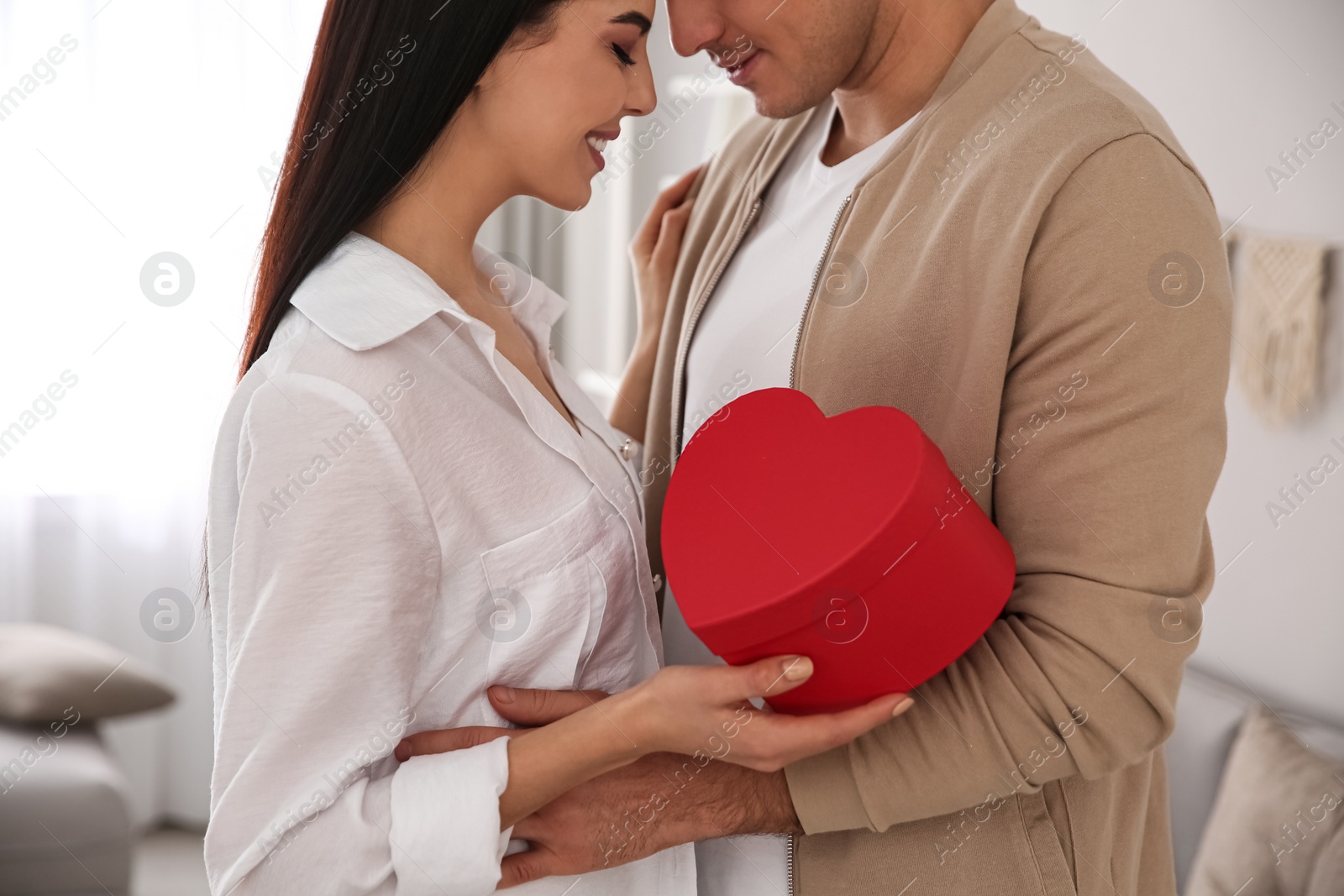 Photo of Lovely couple with gift box at home. Valentine's day celebration