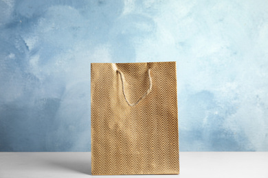 Photo of Gold shopping paper bag on white table