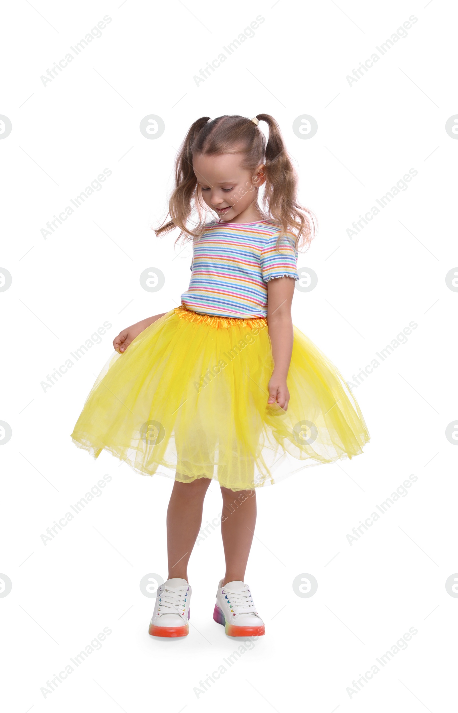 Photo of Cute little girl in tutu skirt dancing on white background