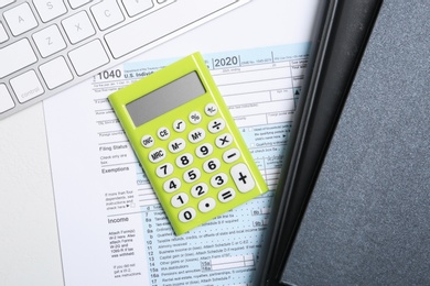 Photo of Calculator, document and notebooks on white table, flat lay. Tax accounting