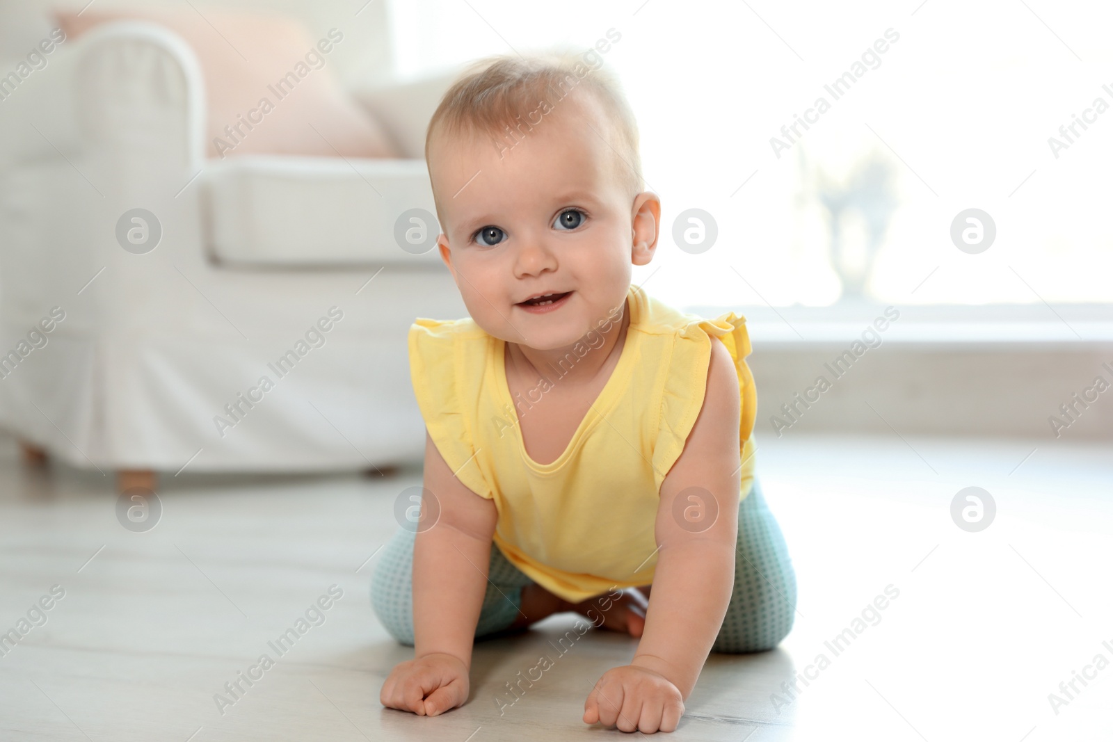 Photo of Cute baby girl on floor in room