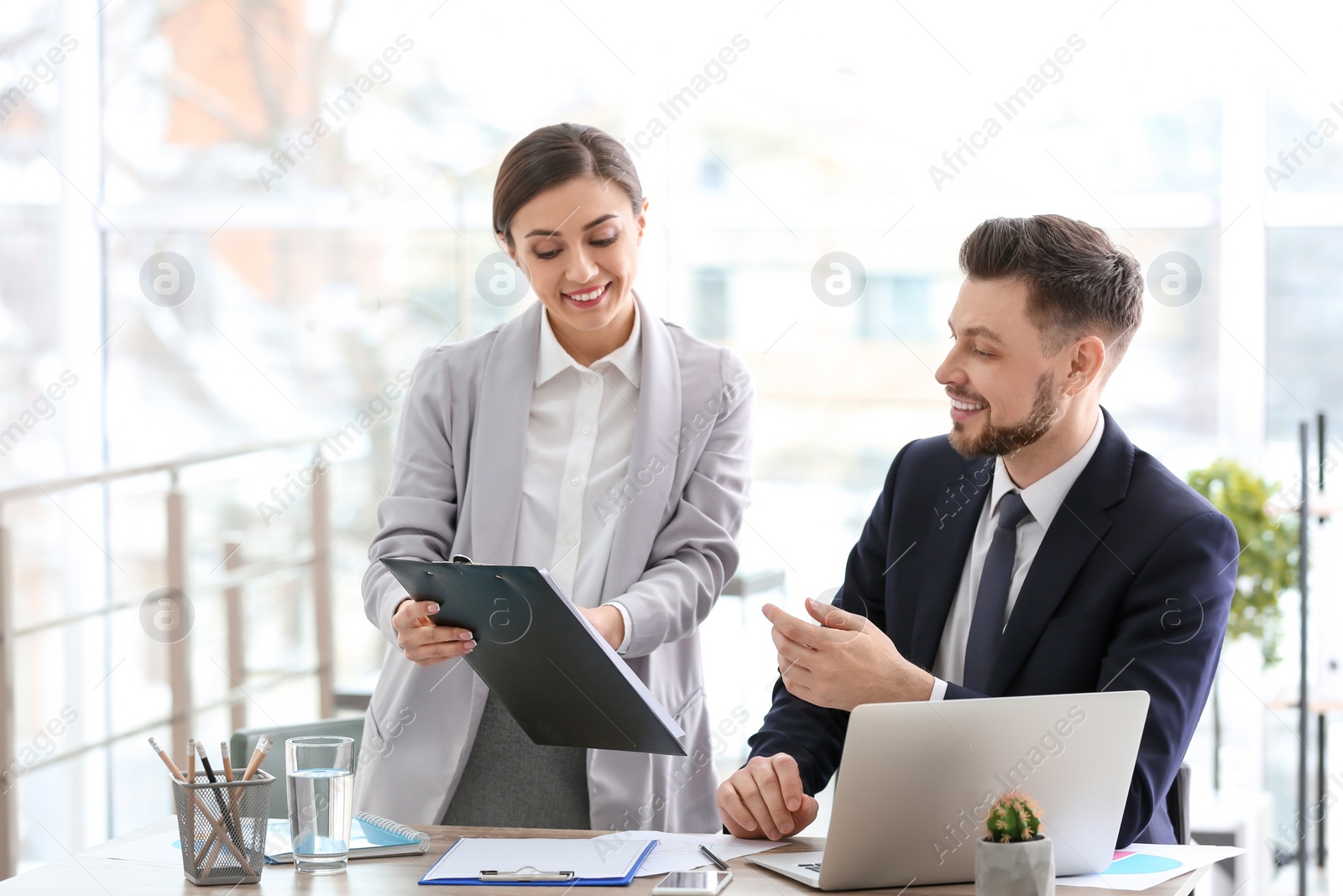 Photo of Young consultant working with client in office