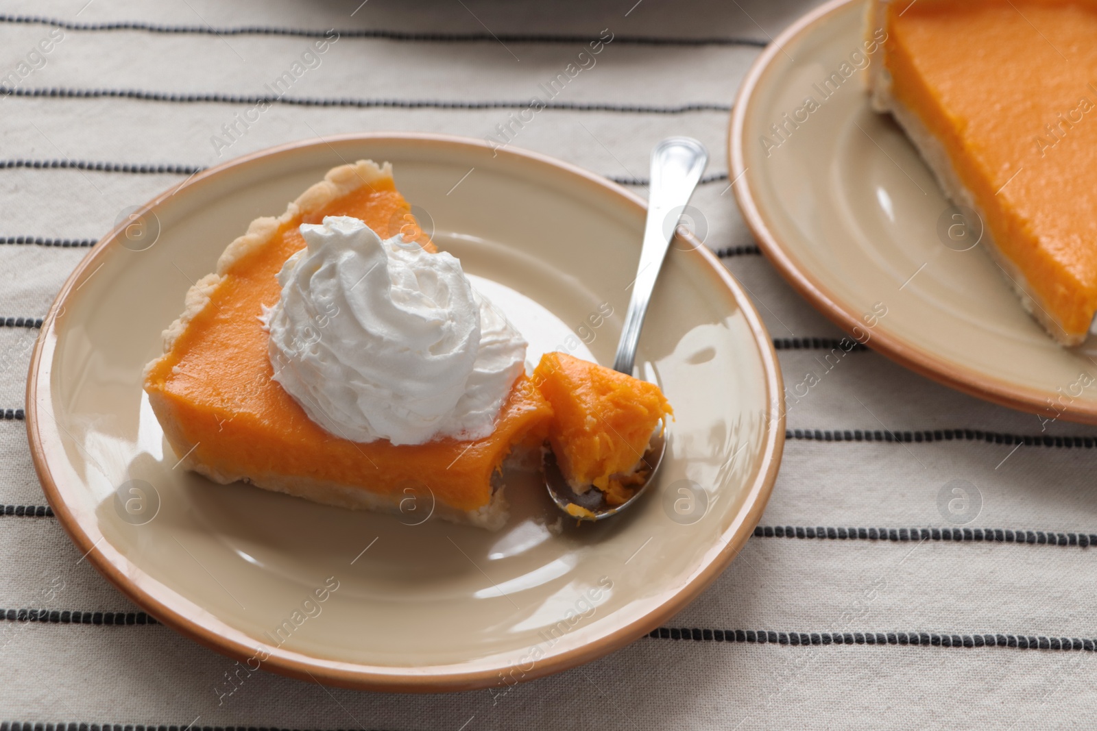 Photo of Fresh homemade pumpkin pie with whipped cream on table