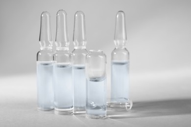 Pharmaceutical ampoules with medication on light grey background