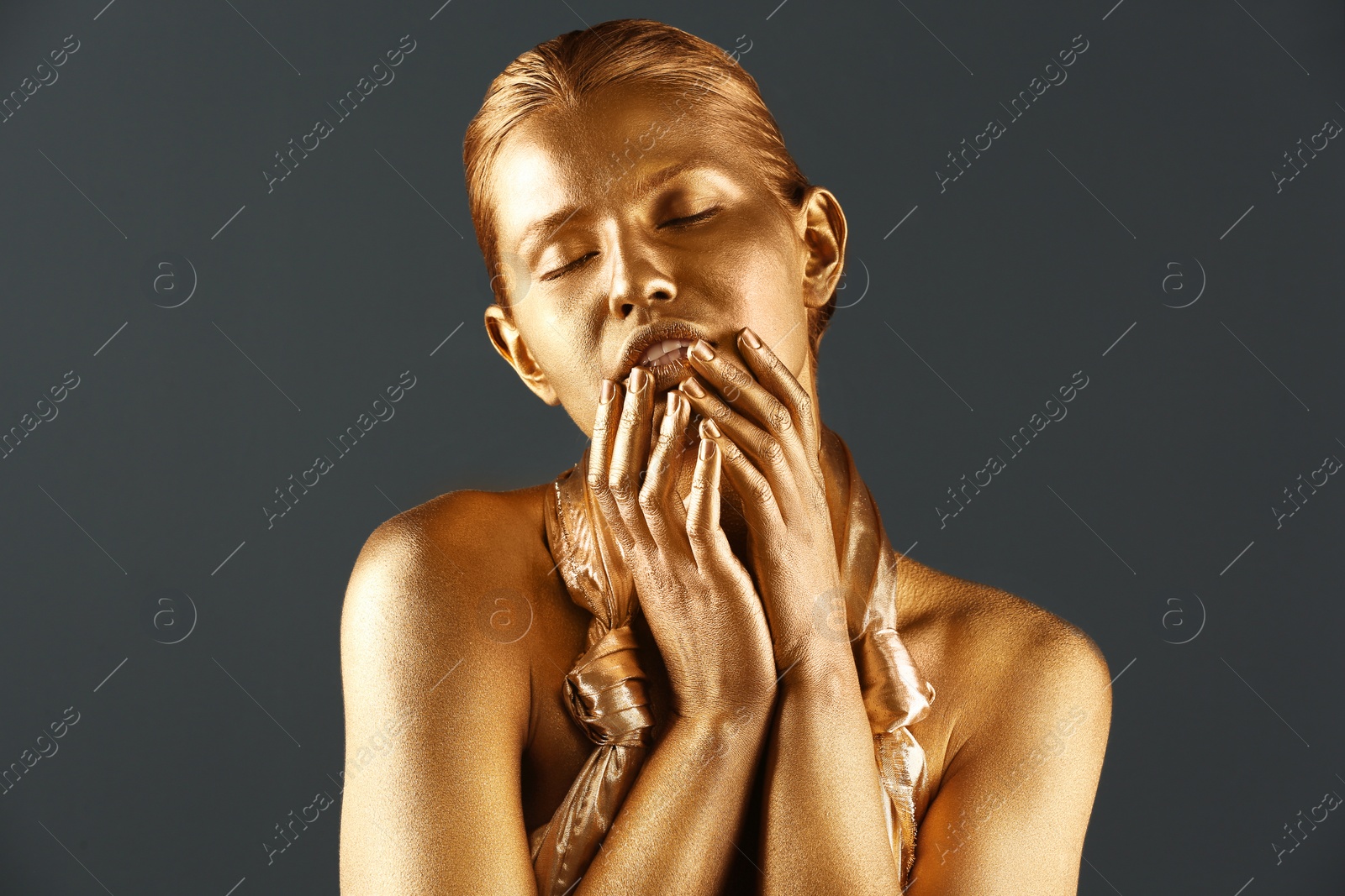 Photo of Portrait of beautiful lady with gold paint on skin against grey background