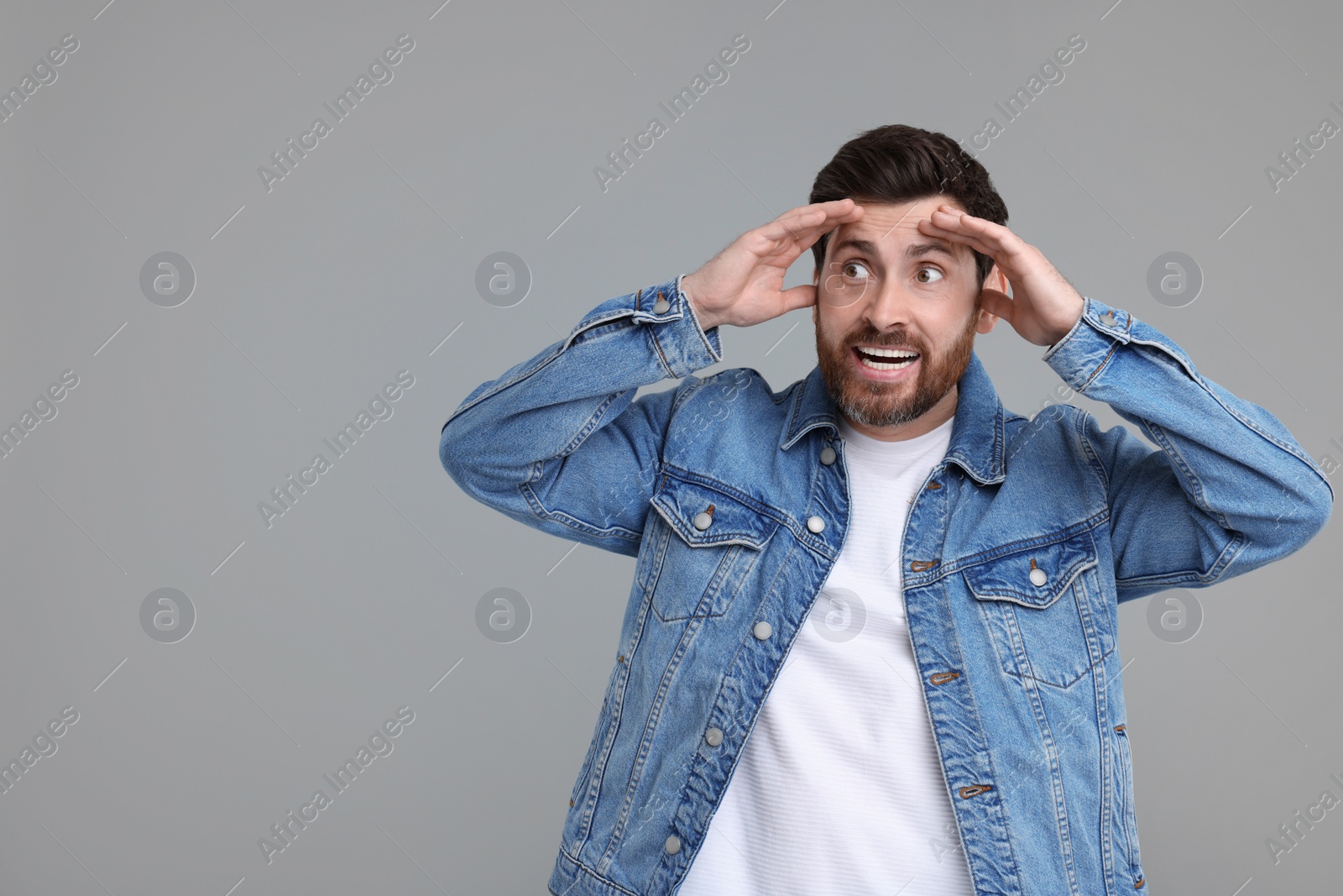 Photo of Portrait of surprised man on grey background, space for text