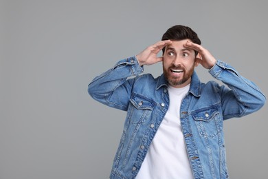 Photo of Portrait of surprised man on grey background, space for text