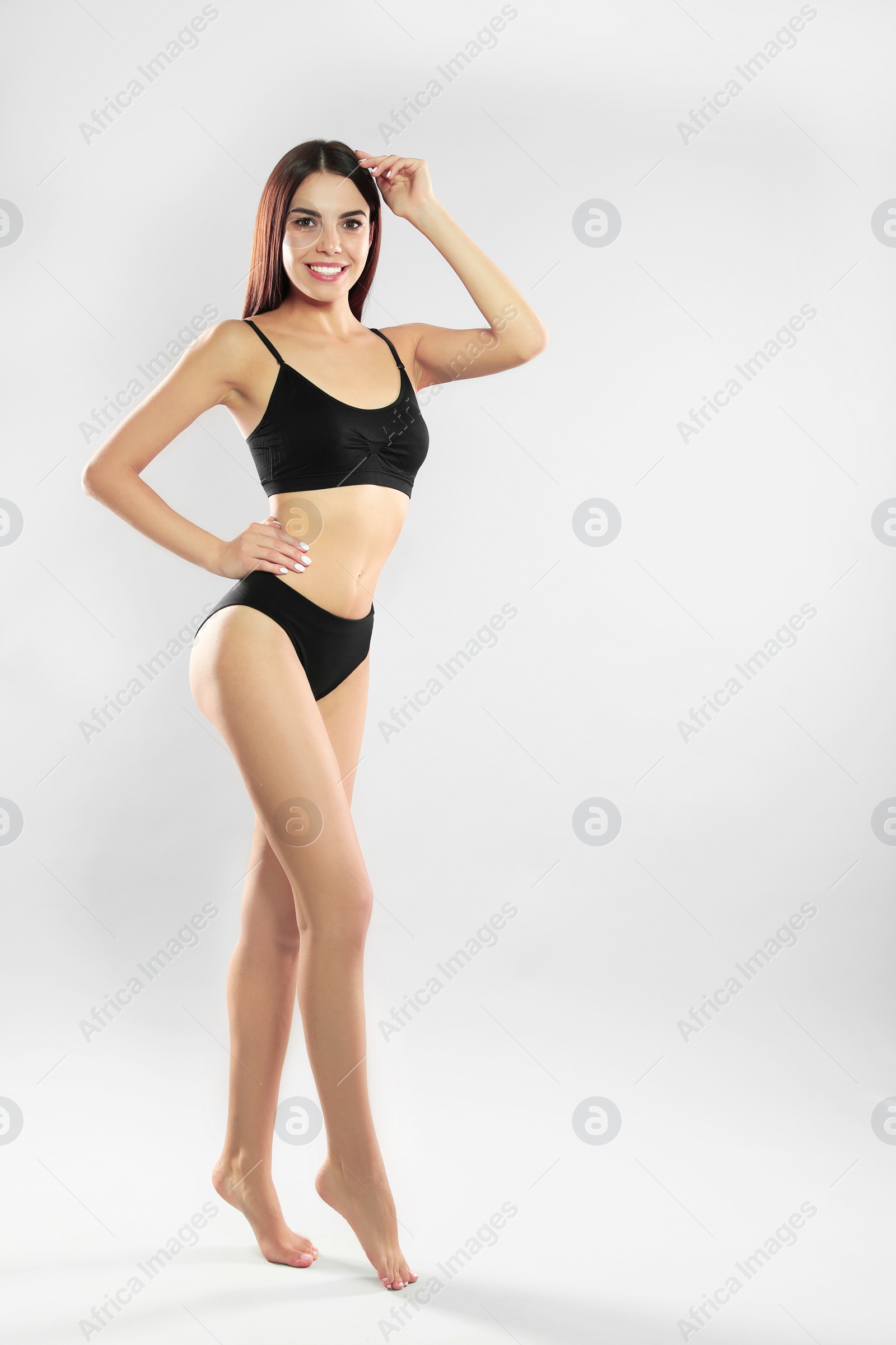 Photo of Full length portrait of attractive young woman with slim body in swimwear on white background. Space for text