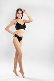 Photo of Full length portrait of attractive young woman with slim body in swimwear on white background. Space for text