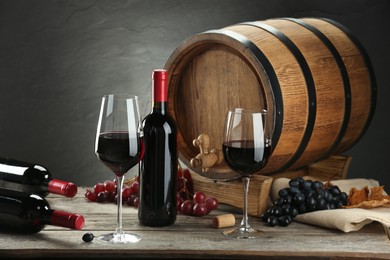 Winemaking. Composition with tasty wine and barrel on wooden table against gray background