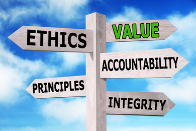 Image of Moral values concept. Wooden signpost with different directions against blue sky