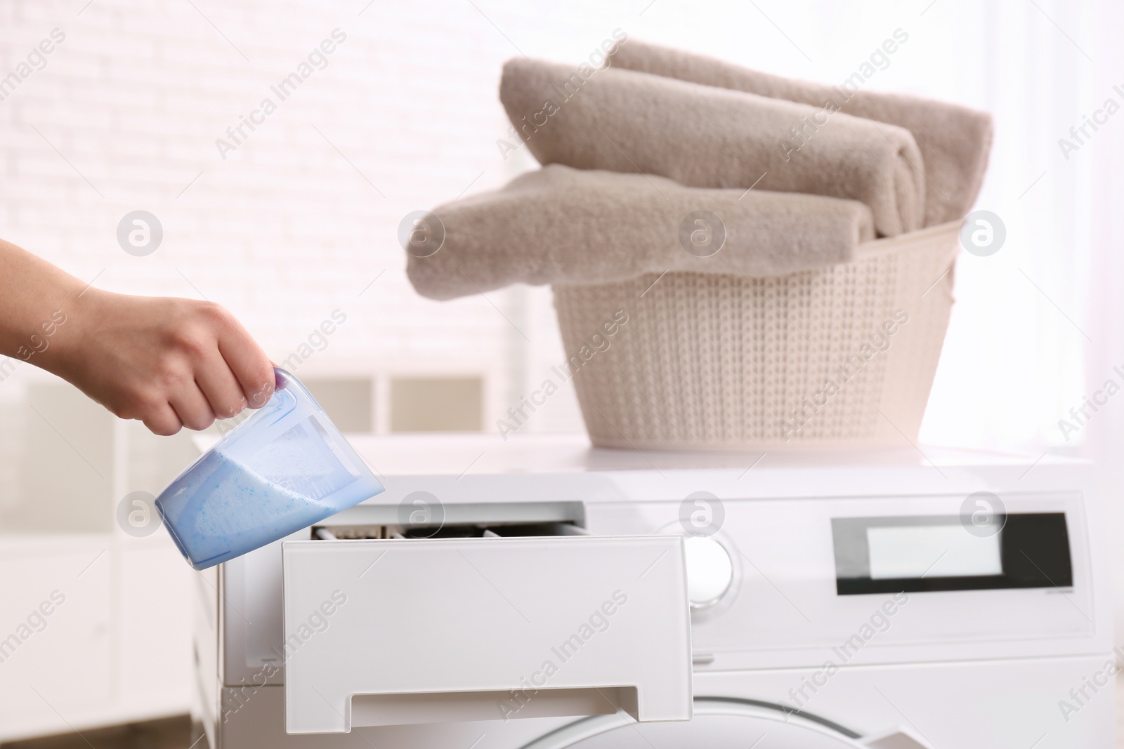 Photo of Woman pouring powder into drawer of washing machine indoors, closeup. Laundry day