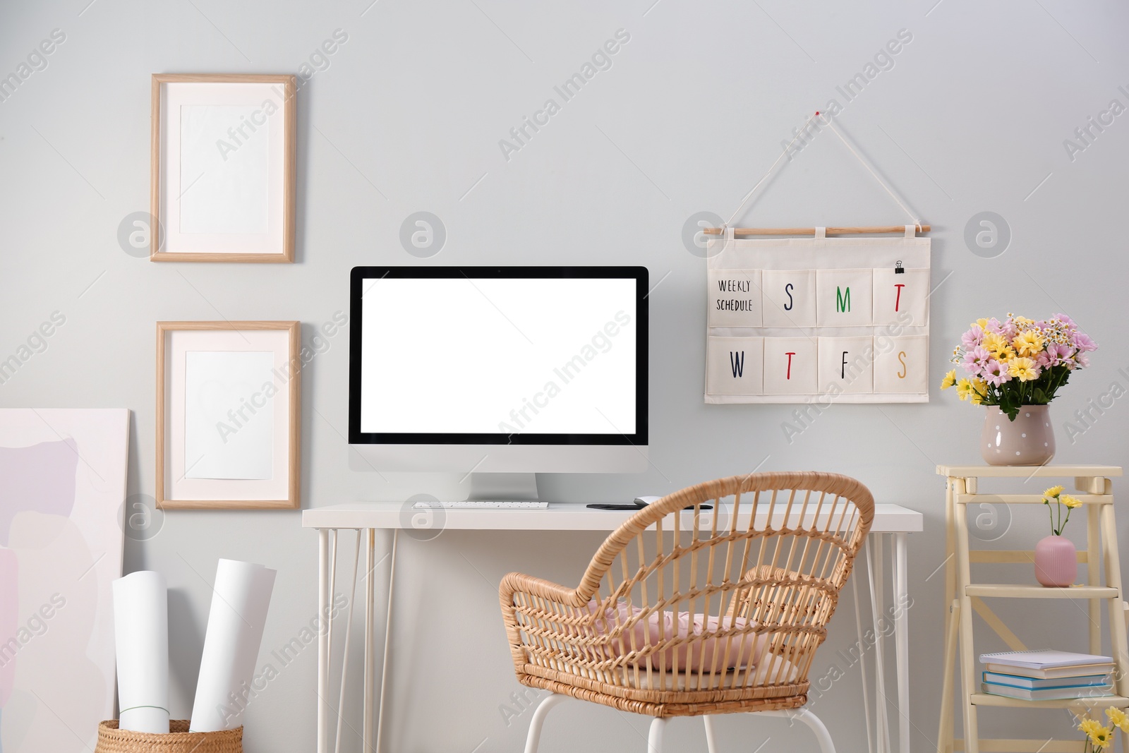 Photo of Comfortable workplace with modern computer and flowers in room. Interior design