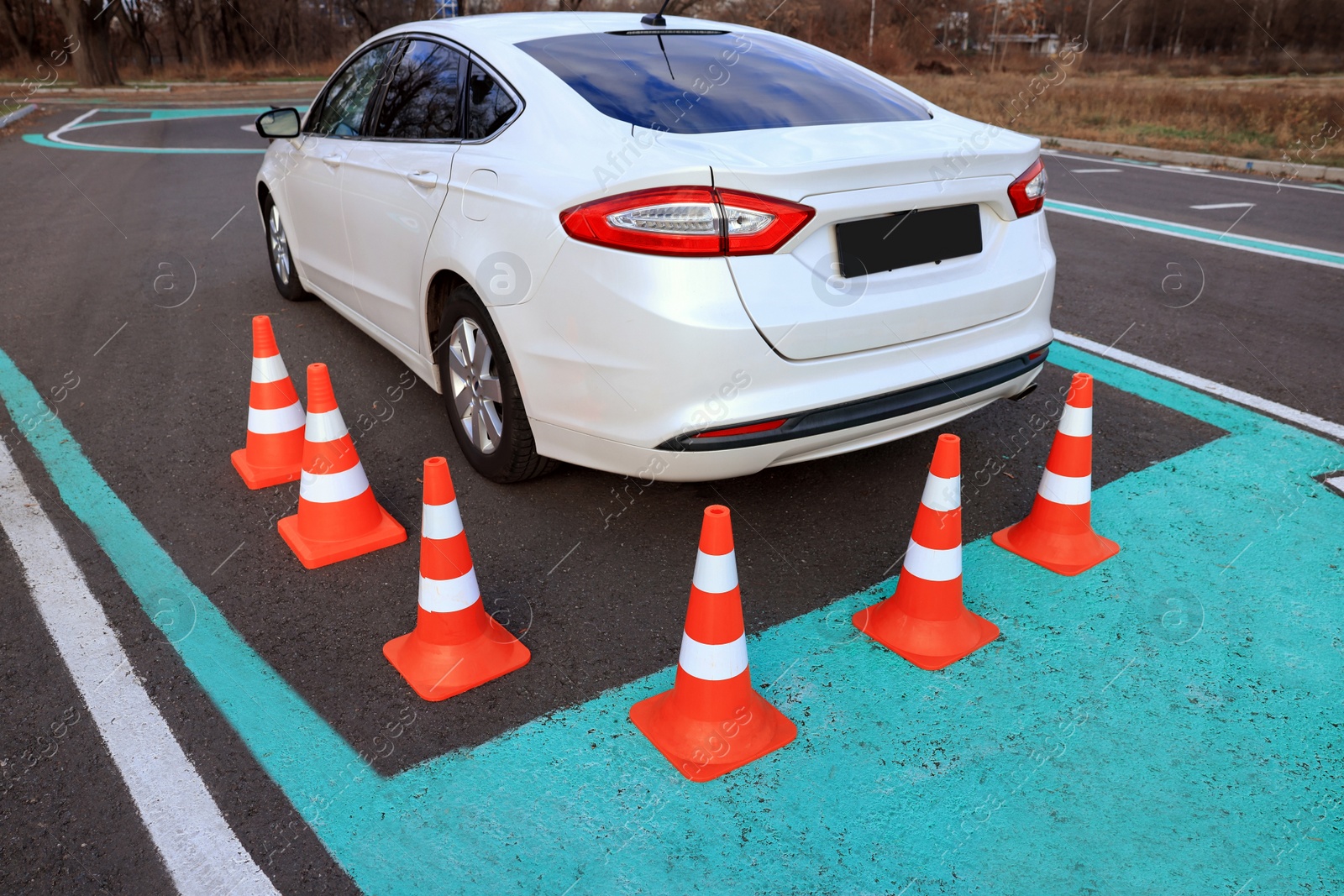 Photo of Modern car on driving school test track with traffic cones