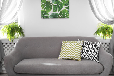 Photo of Modern comfortable sofa with pillows at home. Stylish interior