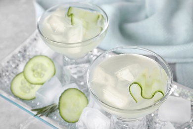 Glasses of tasty cucumber martini on table, space for text