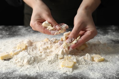 Woman making shortcrust pastry at table, closeup