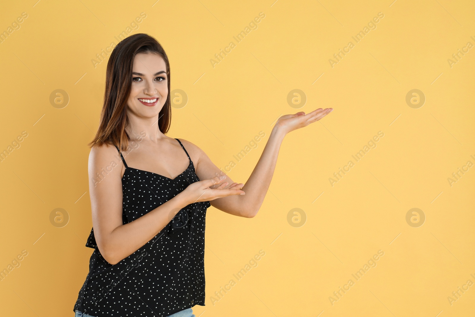 Photo of Happy beautiful young woman on yellow background. Space for text